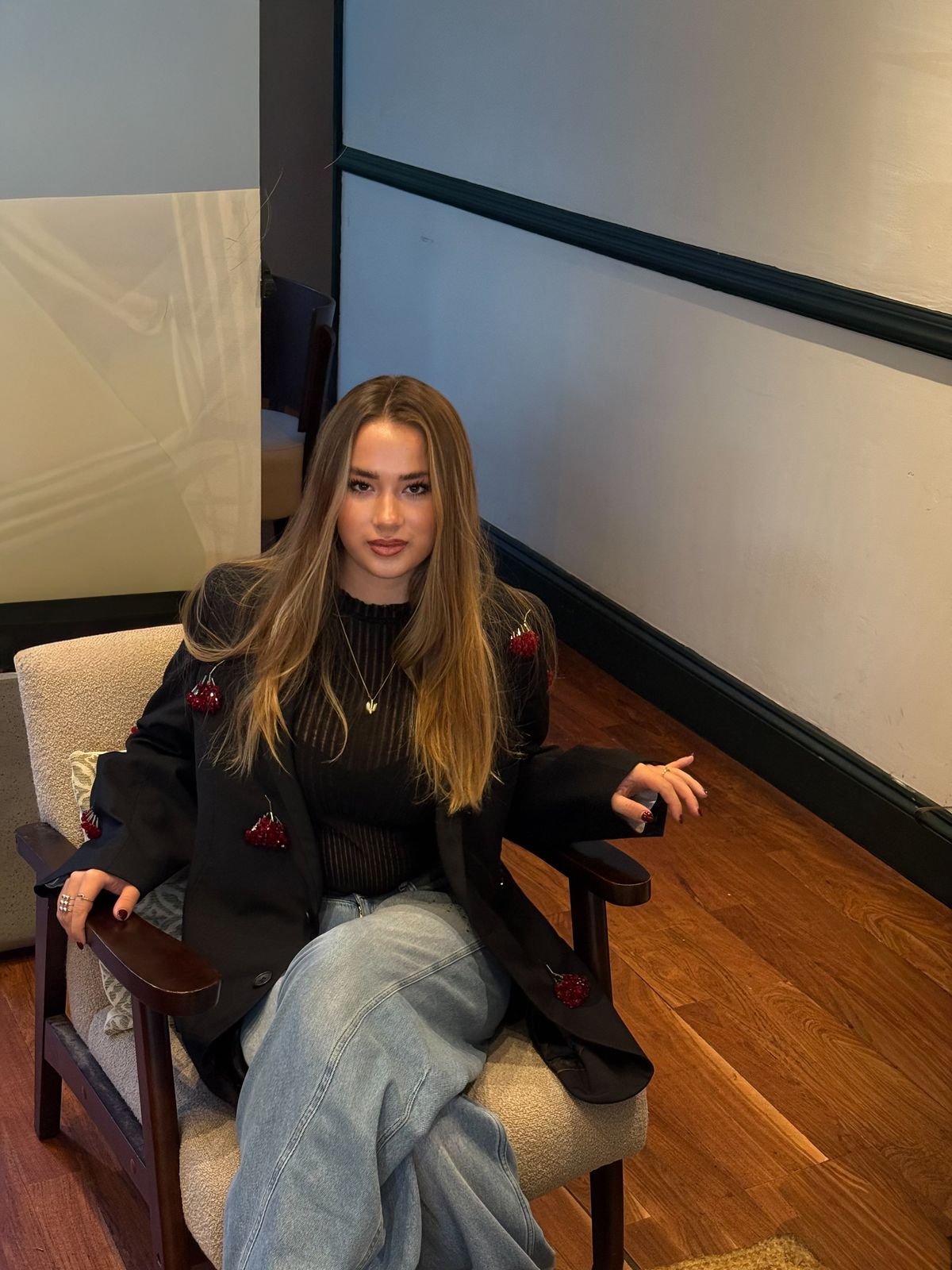 Model seated in an armchair seen from above, wooden floor around her